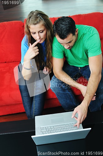 Image of happy couple have fun and work on laptop at home