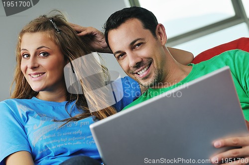 Image of happy couple have fun and work on laptop at home