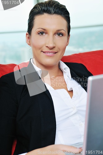 Image of oung business woman working on laptop at home