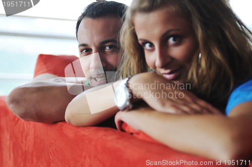 Image of happy couple relax on red sofa