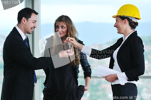 Image of happy young couple buying new home with real estate agent