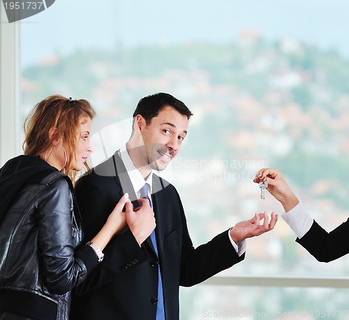 Image of happy young couple buying new home with real estate agent