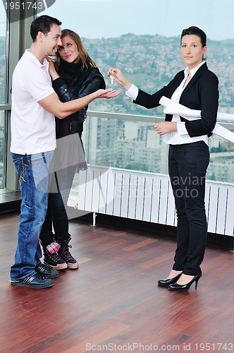 Image of happy young couple buying new home with real estate agent