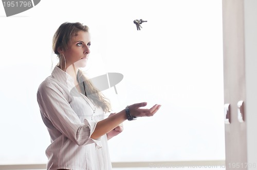 Image of young woman throwing home keys in air