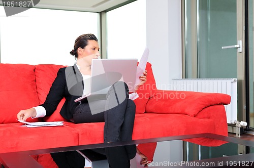 Image of young business woman working on laptop at home
