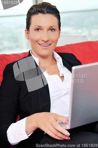 Image of young business woman working on laptop at home