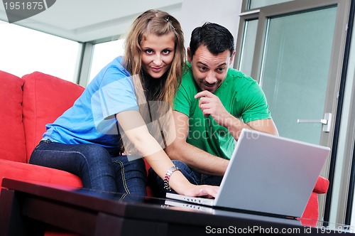 Image of happy couple have fun and work on laptop at home