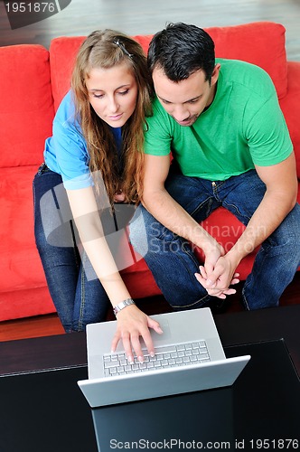 Image of happy couple have fun and work on laptop at home