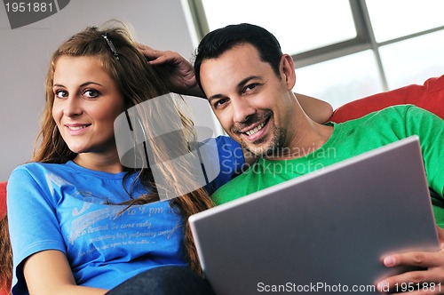 Image of happy couple have fun and work on laptop at home