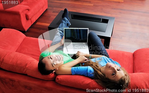 Image of happy couple have fun and work on laptop at home