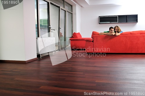 Image of happy couple relax on red sofa