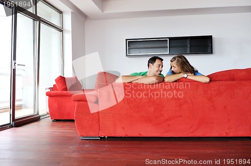 Image of happy couple relax on red sofa