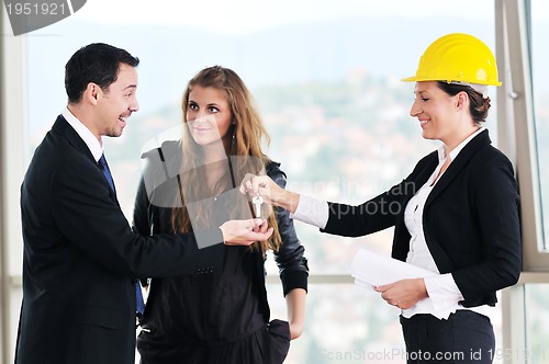 Image of happy young couple buying new home with real estate agent