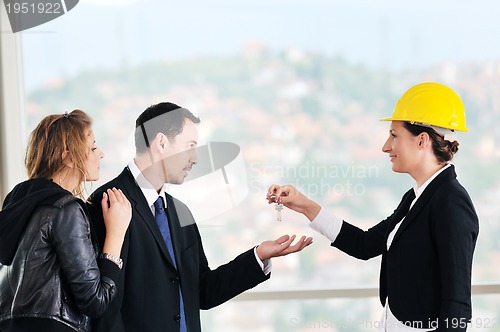 Image of happy young couple buying new home with real estate agent