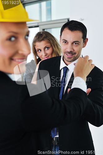 Image of happy young couple buying new home with real estate agent