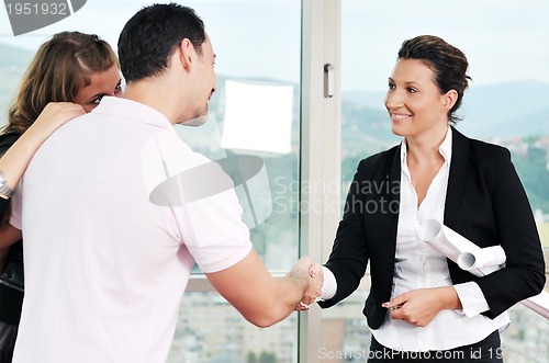 Image of happy young couple buying new home with real estate agent