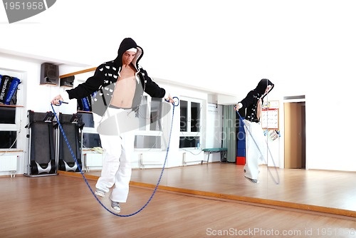 Image of .young man using a jump rope