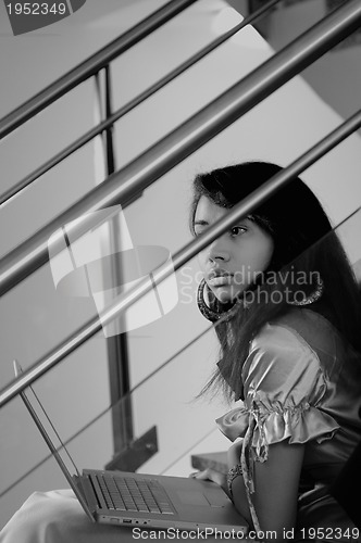 Image of business woman with laptop on staircase