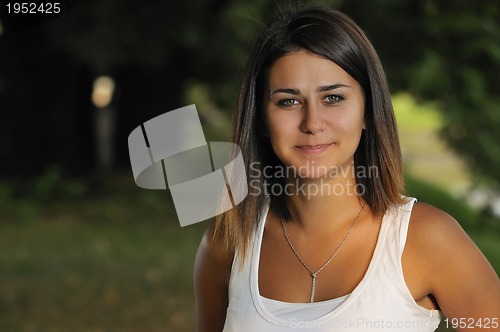 Image of brunette Cute young woman smiling outdoors in nature