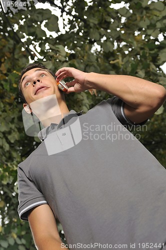 Image of young casual man talking on cellphone