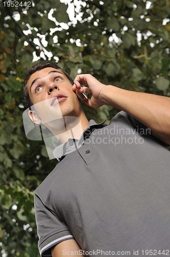 Image of young casual man talking on cellphone