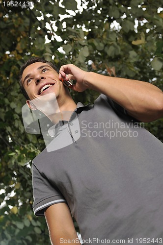 Image of young casual man talking on cellphone