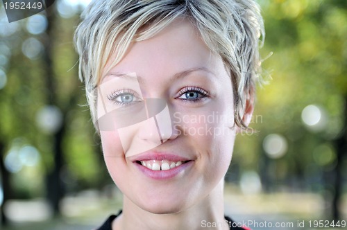 Image of blonde Cute young woman smiling outdoors