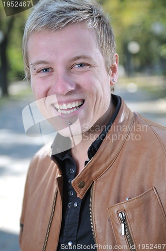 Image of Handsome young man smiling outdoors