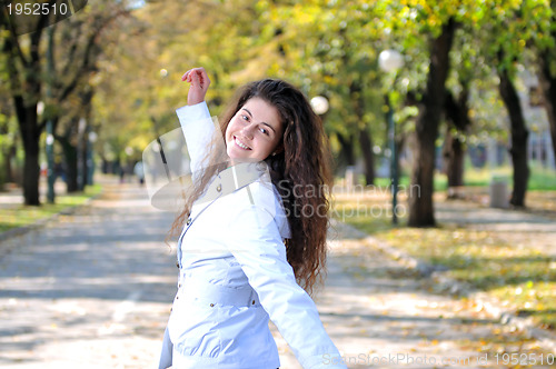 Image of brunette Cute young woman smiling outdoors in nature