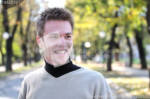 Image of Handsome young man smiling outdoors