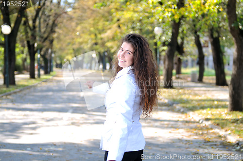 Image of brunette Cute young woman smiling outdoors in nature