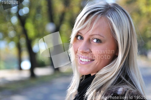 Image of blonde Cute young woman smiling outdoors