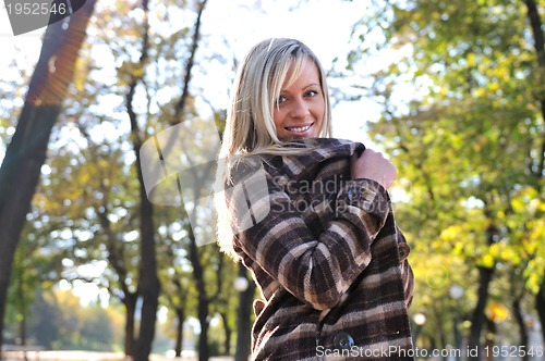 Image of blonde Cute young woman smiling outdoors