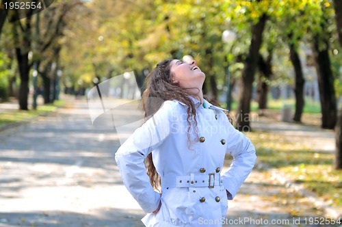 Image of brunette Cute young woman smiling outdoors in nature