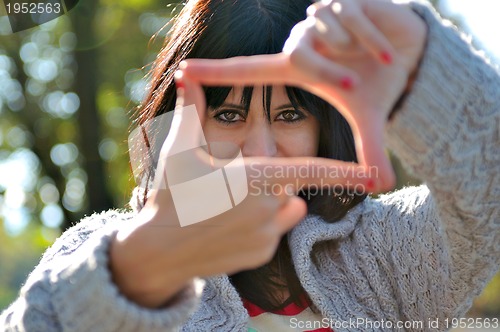 Image of Young woman pretending to see throuhg a  lens