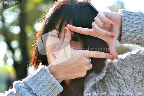 Image of Young woman pretending to see throuhg a  lens