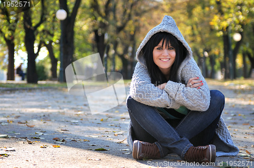 Image of Cute young woman smiling outdoors in nature