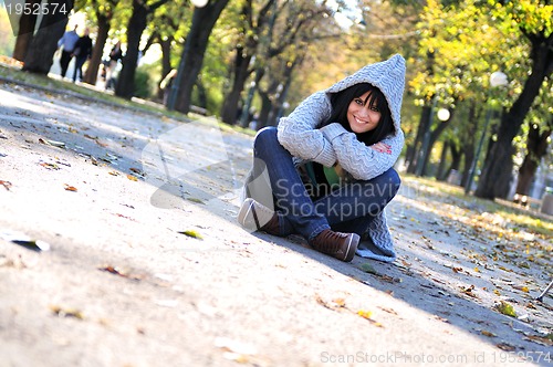 Image of Cute young woman smiling outdoors in nature