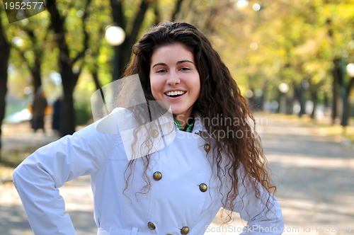 Image of brunette Cute young woman smiling outdoors in nature