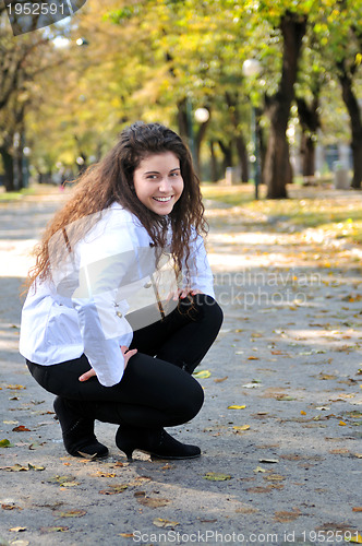 Image of brunette Cute young woman smiling outdoors in nature