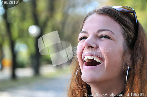 Image of brunette Cute young woman smiling outdoors in nature