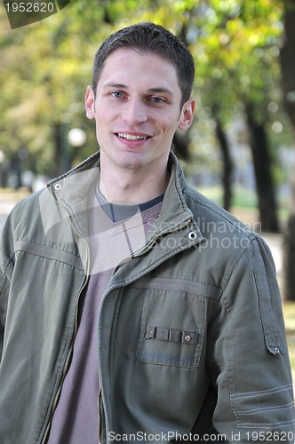 Image of Handsome young man smiling outdoors