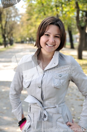 Image of brunette Cute young woman smiling outdoors in nature