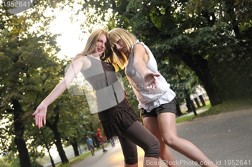 Image of two girls together outside in dancing position ready for party