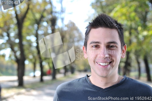 Image of Handsome young man smiling outdoors