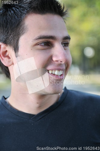 Image of Handsome young man smiling outdoors