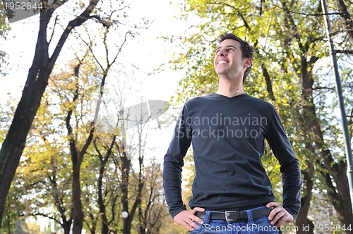 Image of Handsome young man smiling outdoors