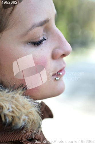 Image of brunette Cute young woman with piercing posing outdoors