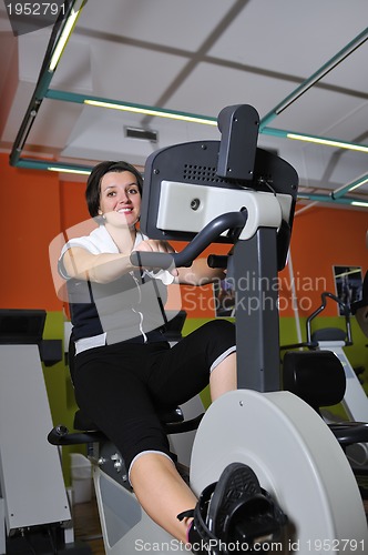 Image of Young woman working out in gym