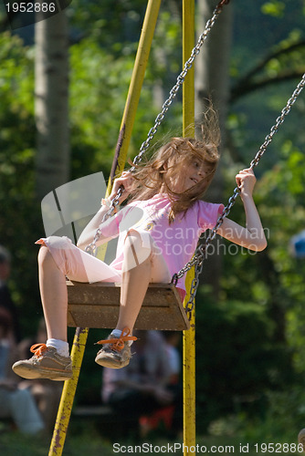 Image of happy girl swinging 